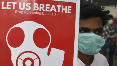 AFP/Getty A demonstrator in Delhi holding a sign reading: Let us breathe