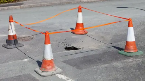 Getty/Ashley Cooper A stock image of a sinkhole opening up in the road in Ambleside, due to being undermined by flood waters
