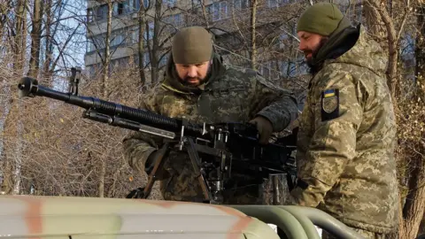 EPA Two Ukrainian servicemen check an anti-aircraft machine gun