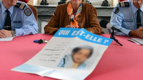AFP Police and a prosecutor present a leaflet to the media with a picture of the girl and a message reading "Who is she?"