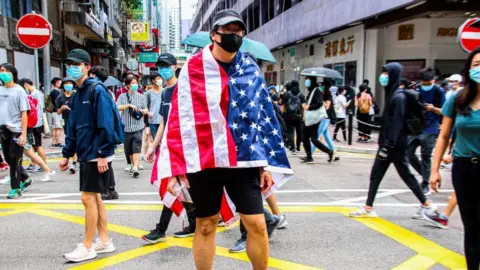 Getty Images One Hong Kong protester is draped with the US flag during the 24th May 2020 protests.