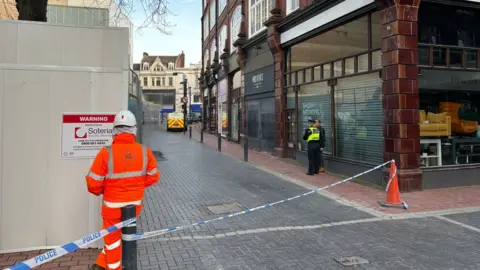 BBC/WILL ROSE Man standing in front of cordon
