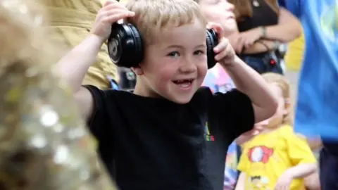 A young blonde boy in headphones