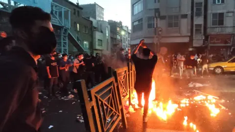 People clash with police during a protest following the death of Mahsa Amini, in Tehran, Iran (21 September 2022)