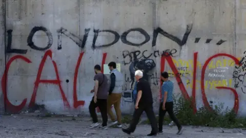 Reuters People in Calais' "Jungle" migrant camp in 2016