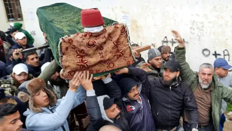 Reuters People carry the coffin of Omar Tayba, who was killed at a protest in Tripoli, Lebanon. Photo: 28 January 2021