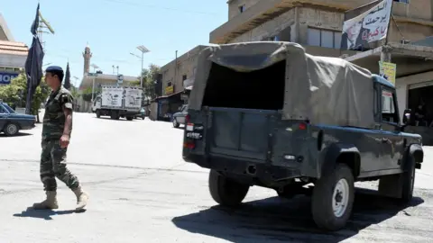 Reuters A Lebanese army soldier walks near a military vehicle at the entrance of the border town of Arsal, in eastern Bekaa Valley, Lebanon June 30, 2017