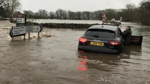 Thomas Beresford A car in floods in Hawes