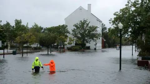 Getty Images Residents walk in flooded streets as the Neuse River floods its banks during Hurricane Florence