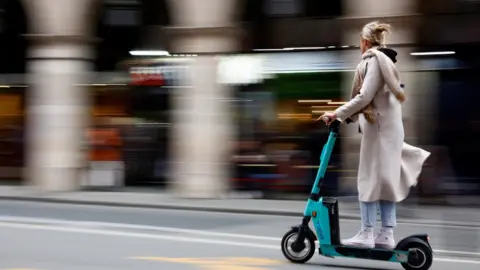 Reuters A woman rides an electric scooter in Paris