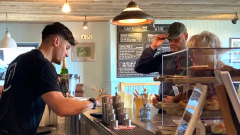 Bar worker serves two customers