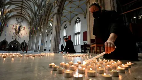 Getty Images A verger lights one of 4,161 candles representing each death from Covid-19 in Lancashire county at Blackburn Cathedral