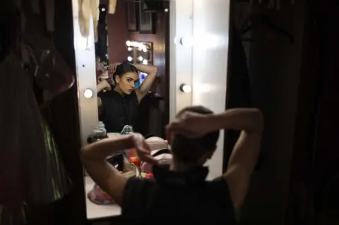 Kim Ludbrook/EPA Veronica Louwe doing her hair in the mirror backstage