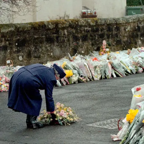 PA Media Queen Elizabeth II laying a wreath at the gates of Dunblane Primary School after one of the deadliest firearms incidents in UK history.