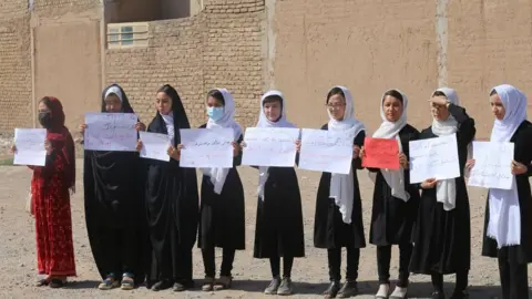 Getty Images A number of girls in Herat gather to stage a demonstration demanding to continue their education in schools and universities