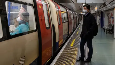 EPA Man wearing a face mask on a Tube platform in London