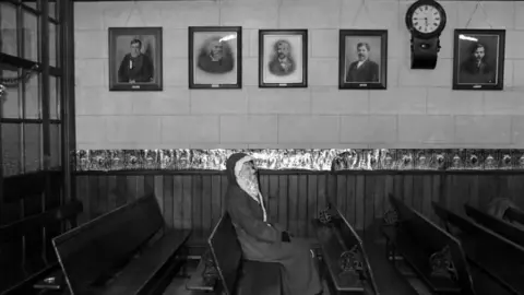 Malcolm Glover Father Christmas sitting in a church in Tudweiliog