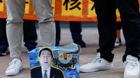 Reuters A cardboard sign with Japan's Prime Minister Fumio Kishida is seen during a protest in Hong Kong on Friday after Japan released treated radioactive water from the crippled Fukushima nuclear plant into the sea