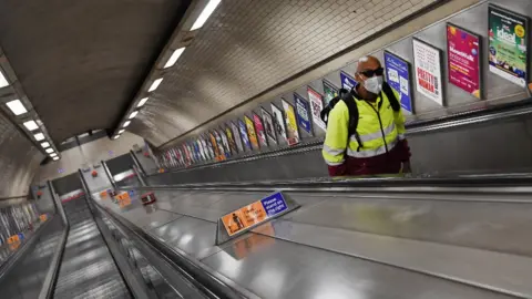 EPA A commuter in a face mask on the London Underground escalators