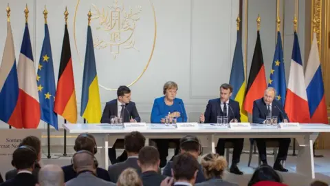 Getty Images Ukraine's President Volodymyr Zelensky (L), Germany's Chancellor Angela Merkel (2nd L), France's President Emmanuel Macron (2nd R), and Russia's President Vladimir Putin (R) attends to news conference after a Normandy Four summit at the Elysee Palace in Paris, France on December 10, 2019