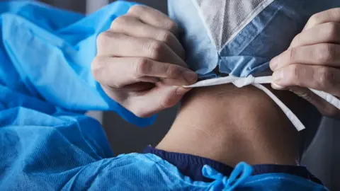 Getty Images Man wearing medical gown
