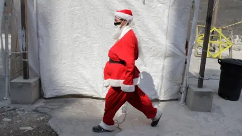 Getty Images A volunteer characterized as Santa Claus to deliver food, toys and blankets to street populations and people at risk in Mexico City