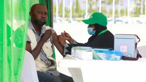 Reuters A man receives the coronavirus disease (COVID-19) vaccine during the flag-off of mass vaccination of COVID-19 campaign in Abuja, Nigeria, November 19, 2021