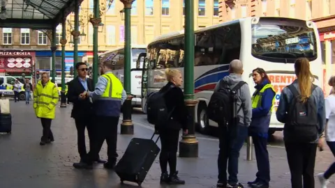 BBC Passengers and ScotRail staff outside Glasgow Central station