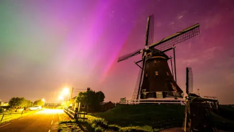 The Northern lights (aurora borealis) lights up the night sky above the Molenviergang in Aarlanderveen, the Netherlands