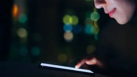 Getty Images Woman looking at her smartphone