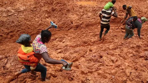 EPA Passengers disembark vehicles and walk through the muddy road, due to heavy Torrential rainfall on the highways of Sinoe County, Liberia, 04 September 2018.