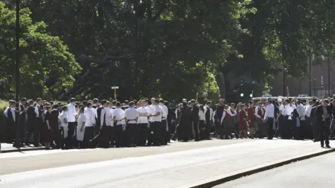 Gordon Lewis A group of staff members gathered in Hyde Park after they were led from the building