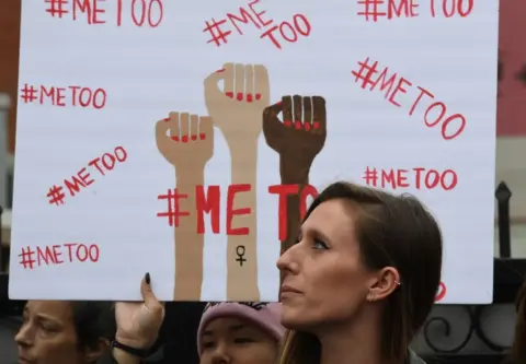 Getty Images protesters hold metoo signs