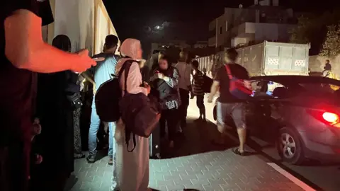 Qutaiba Kolthoum People waiting on the streets of Al-Zahra at night