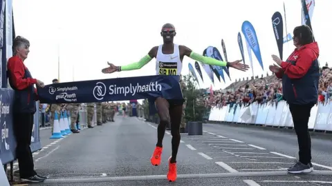 Getty Images Sir Mo Farah crosses the finish line in the men's elite race