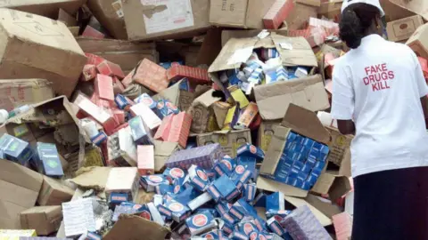 Getty Images This file picture dated 13 October 2001 shows an official of the National Agency for Food and Drug Administration and Control (NAFDAC) off-loading cartoons of fake drugs for destruction 13 October 2001, at the premises of the agency in Lagos