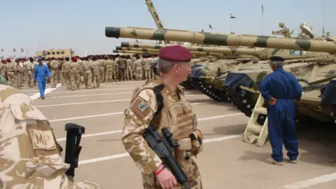 Contributed image Many soldiers standing on the tarmac at an airbase with planes in the background