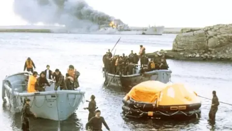 PA Media Survivors coming ashore from the bombed Sir Galahad