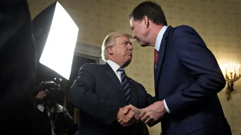 Getty Images James Comey and Donald Trump shake hands in 2017.