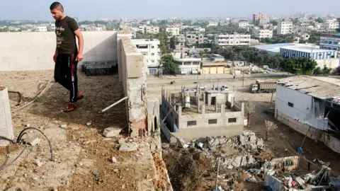 Getty Images Man stands by rubble in Gaza