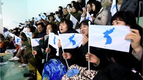 EPA People wave the Korean Unification Flag, while the joint Korean women"s hockey team faces Sweden - 5 February 2018