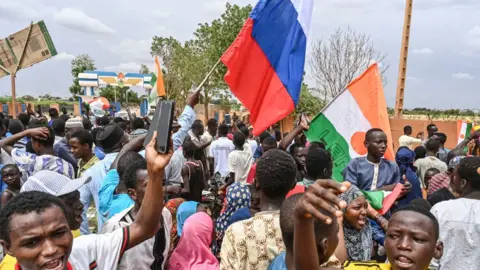 Getty Images A Russian flag being waved amid a crowd in Niger