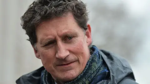 Getty Images Eamon Ryan pictured outside wearing a scarf and coat with a serious expression