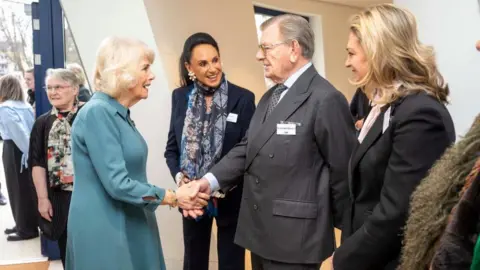 Daily Telegraph/ PA Queen Camilla shakes hands with Sir Gerald Ronson as others watch on