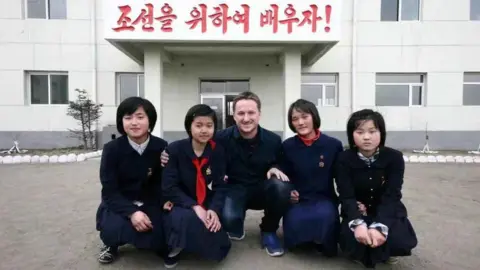 Reuters Canadian businessman Michael Spavor poses with girls at a school in Rason Special Economic Zone, North Korea