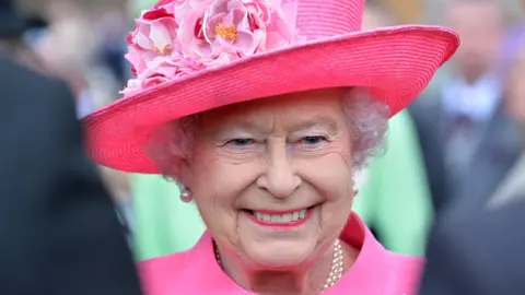 Crown Copyright / Steve Blake Photo of the Queen smiling and wearing a bright pink hat