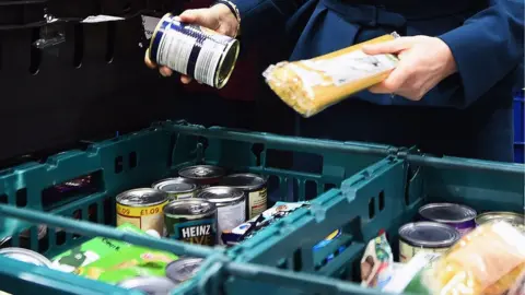 PA Media Person sorting food in a food bank