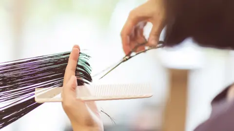 Getty Images A hairdresser cutting hair (file image)