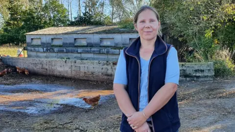 Jenny Kirk/BBC Rebecca Mayhew with some of her chickens