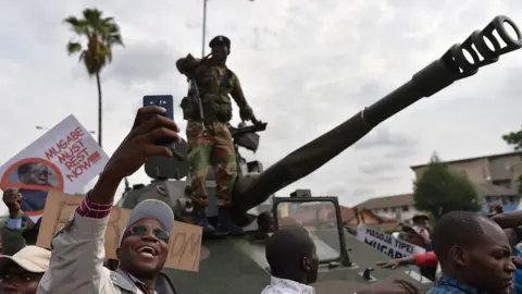 AFP A man takes a selfie-picture of a Zimbabwean Defence Force soldier standing on a tank during a march in the streets of Harare, on November 18, 2017 to demand to the 93 year-old Zimbabwe's president to step down